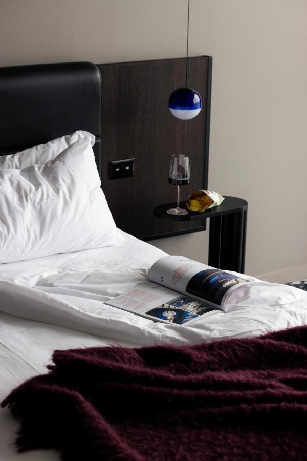 Ebb-דנידין מראה חיצוני תמונה A bed with a magazine and a wine bottle